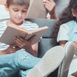 Kinder lesen in einem Buch über Maria Montessori
